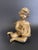 A vintage gold-painted cherub gracefully seated while holding a lyre harp. This lovely piece is perfect for display on a...