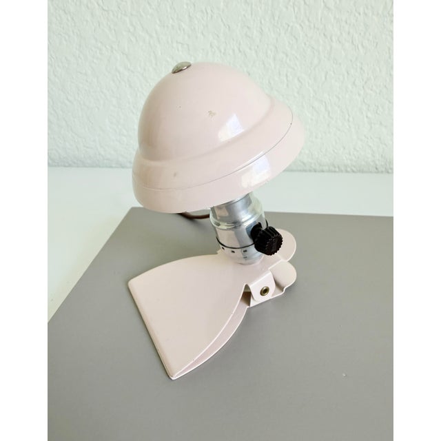 Vintage circa 1950s mini metal clip lamp that features a mushroom-shaped shade, light pink paint on an aluminum frame with...