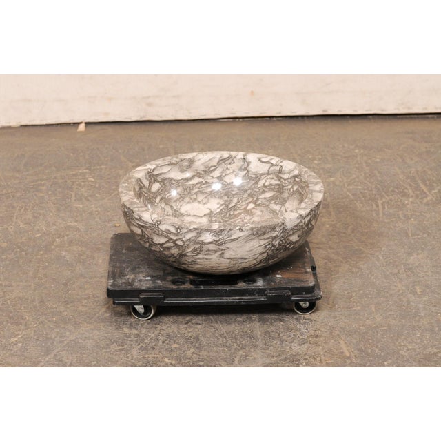 A single round-shaped onyx sink basin. This carved vessel sink, created from a single onyx rock, has been carved and then...