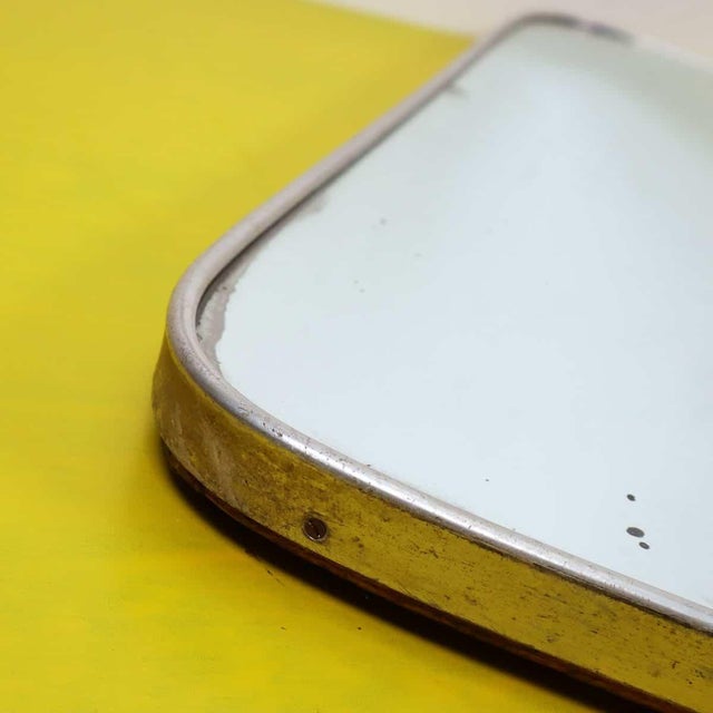 1940s wooden mirror with aluminum edge Height: 48.5 Width: 59 Depth: 3 This piece is attributed to the mentioned...