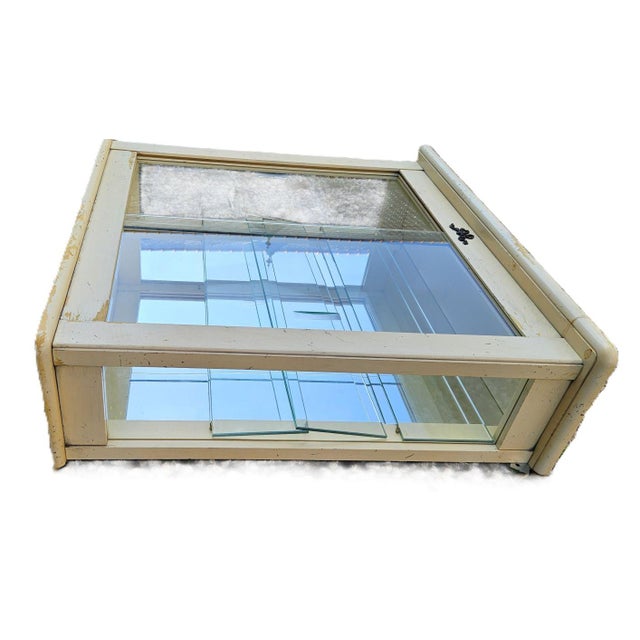 Small painted wood wall display case decorated with a louis xvi knot on the front. It is glazed on both sides. The...