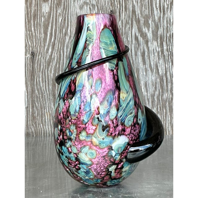 This exquisite hand-blown art glass vase is a captivating fusion of color and form. The striking marbled pattern,...