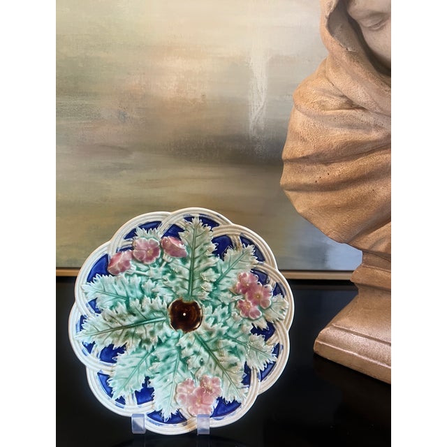Late 19th Century majolica wall plate with leaves and flowers in high relief and a scalloped edge.