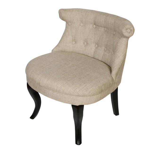 A pair of neutral linen shaped slipper chairs with tufted, curved back and curved, dark front legs