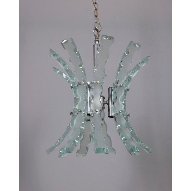 Chandelier with chromed metal structure and hand-worked thick glass plates, designed by Studio Zeroquattro, 1970s. I have...