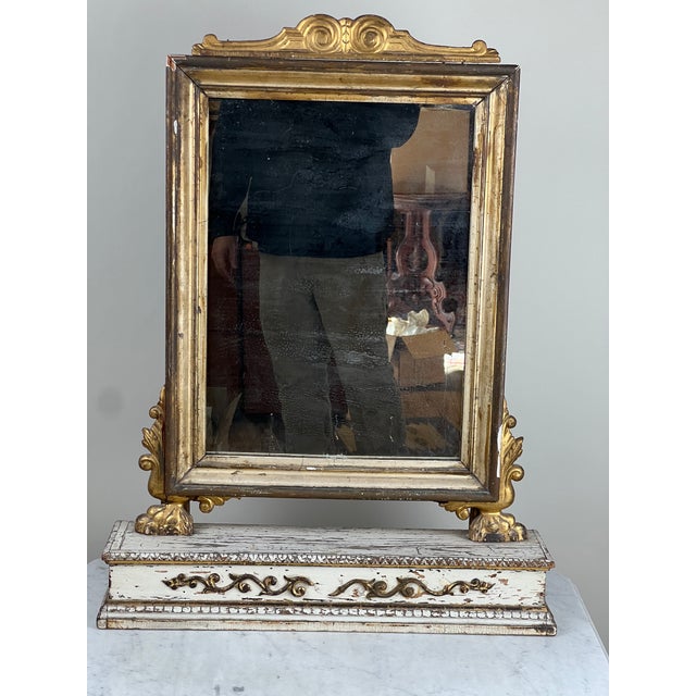 This elegant French Empire gilt wood vanity mirror dates to the mid-19th century and beautifully reflects the refined...