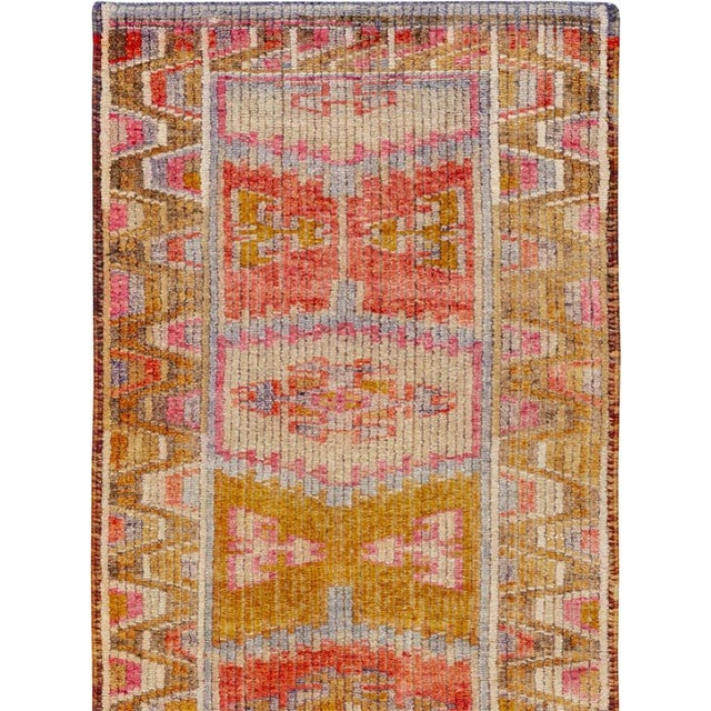 This mid-20th-century Turkish Anatolian runner presents a lively vertical sequence of geometric medallions framed by broad...