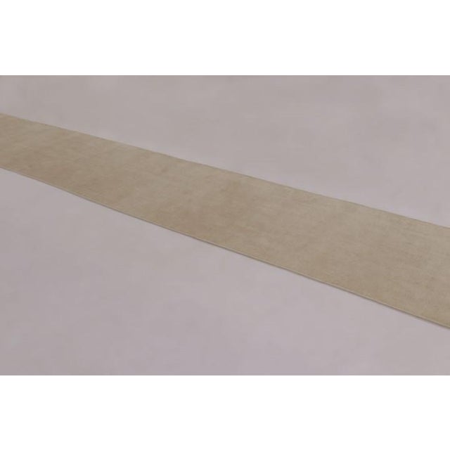 Made with a luxurious blend of silk, this 3x19 contemporary extra-long runner rug is a luminous masterclass in luxury,...