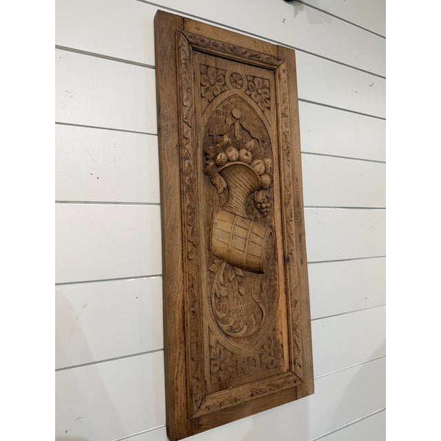Hand-carved solid wood wall panel depicting a cornucopia overflowing with fruit, rendered in deep relief and framed by an...