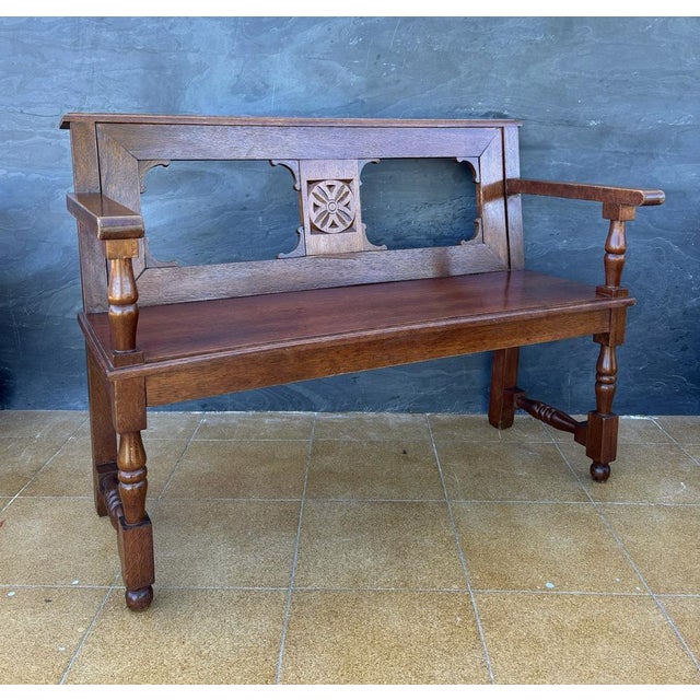Spanish Renaissance Revival bench crafted in solid oak, Early 20th century. The bench features a paneled backrest with...