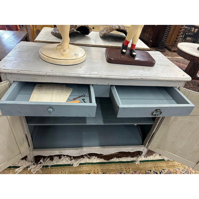 A charming 19th Century French Provincial two-door buffet, featuring a classic Louis XV-influenced silhouette. This piece...