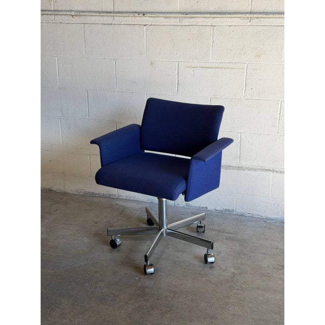 This office desk chair features a supportive backrest and integrated armrests. The design offers smooth swivel mobility on...