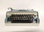 A mid-century Italian typewriter from the 1960s. The vintage portable typewriter is blue and cream with a gray soft gray...