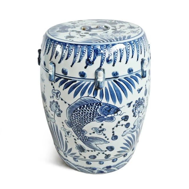 Ceramic garden stool with indigo blue fish and botanical design painted over white background. Beautiful hand crafted and...