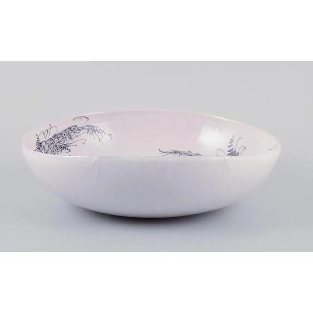 Bjørn Wiinblad, own workshop. Large and early unique earthenware bowl. Motif of two harlequins playing in front of a...