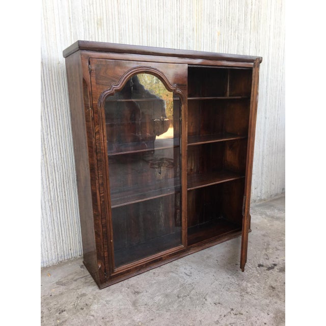This early (circa 1830) French Provincial plantation style walnut bookcase features an upper part topped by a cornice...