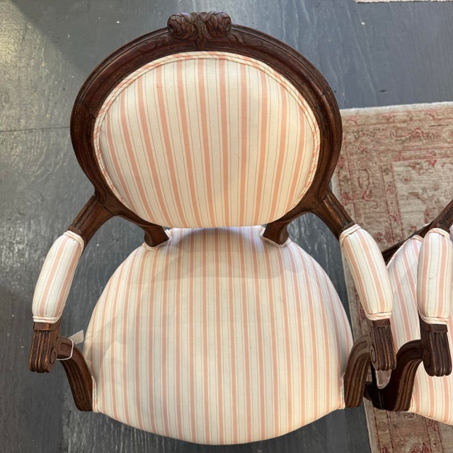 This is a pair of antique Louis XVI style arm chairs. They are from France. The wood is a carved walnut. They a have oval...