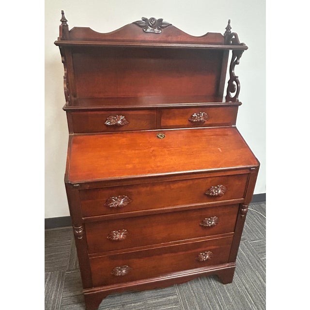 All mahogany slant front secretary desk with five drawers, bookshelves and carved drawer pulls. Front opens to a spacious...
