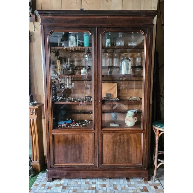 Large Louis-Philippe period library in walnut veneer and solid oak. Opening by two glass doors on a set of a total of ten...