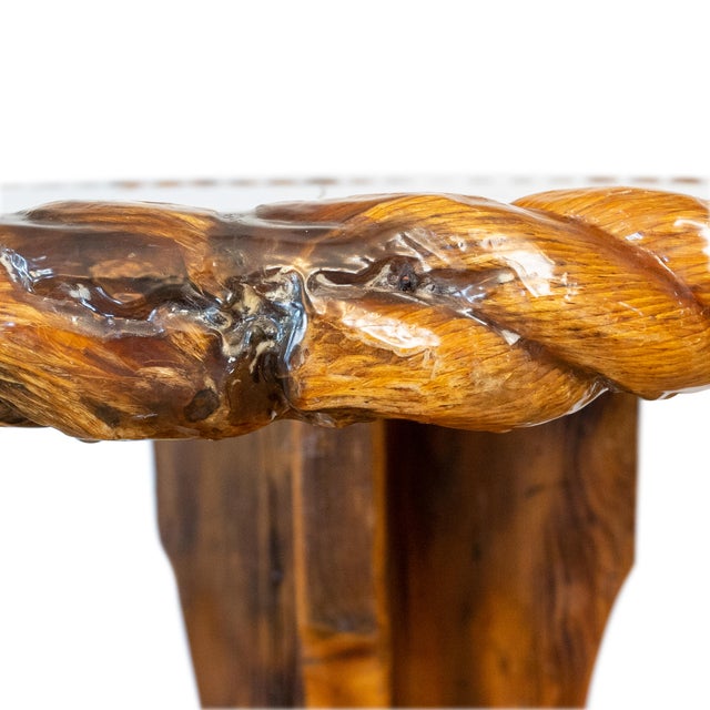 A vintage solid knotty pine pedestal table featuring a distinctive rope-molded edge with a durable resin-coated finish,...