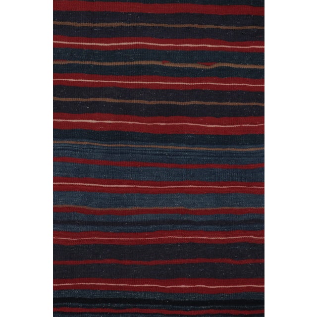 Handwoven in wool, this 4x6 contemporary Rez kilim features layered navy, charcoal, and muted red stripes. Its balanced...