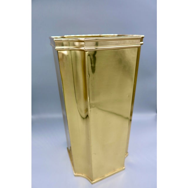 A tall, tapered hexagonal brass umbrella stand with a stepped molded rim and scalloped cut-out base — equally at home...