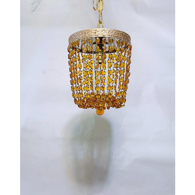 Infuse your space with warmth, character, and a touch of vintage glamour with this captivating amber glass beaded...