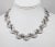 Circa 1956 rhodium plated textured overlapping half moon sections articulated necklace with hook clasp. Marked "MONET" on...