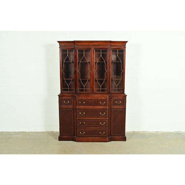 A gorgeous Georgian or Chippendale style breakfront bookcase cabinet with drop front secretary desk In the manner of Baker...