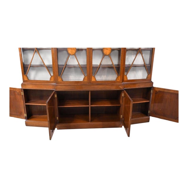 This is a Georgian revival bookcase or display cabinet. It is mahogany with satinwood inlays throughout the upper portion....