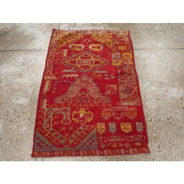 This early 20th century Turkish Anatolian Wagireh rug, measuring 2' 6" x 3' 9", is a vibrant sampler piece traditionally...