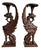 An exceptional and highly sculptural pair of hand-carved griffin pedestal stands, executed in richly toned dark wood and...