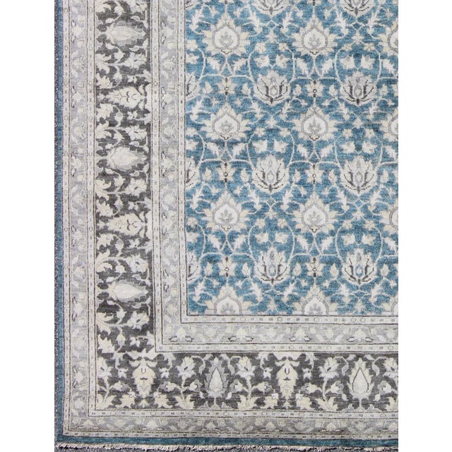 This hand knotted Tabriz rug features a beautiful all-over design rendered in grays, silver, and charcoal and blue tones....