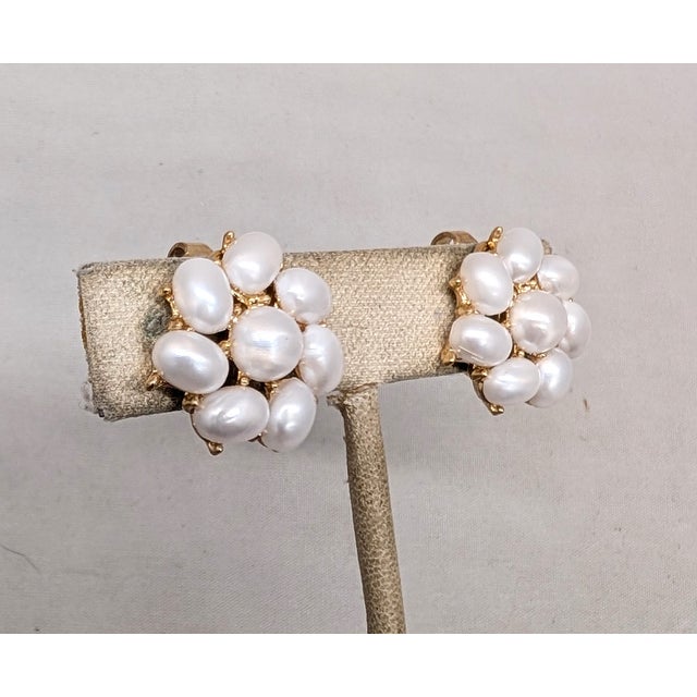 1958 goldtone round faux-pearl center with oval faux-pearl surround clip earrings. Marked crown "TRIFARI" on the clips....