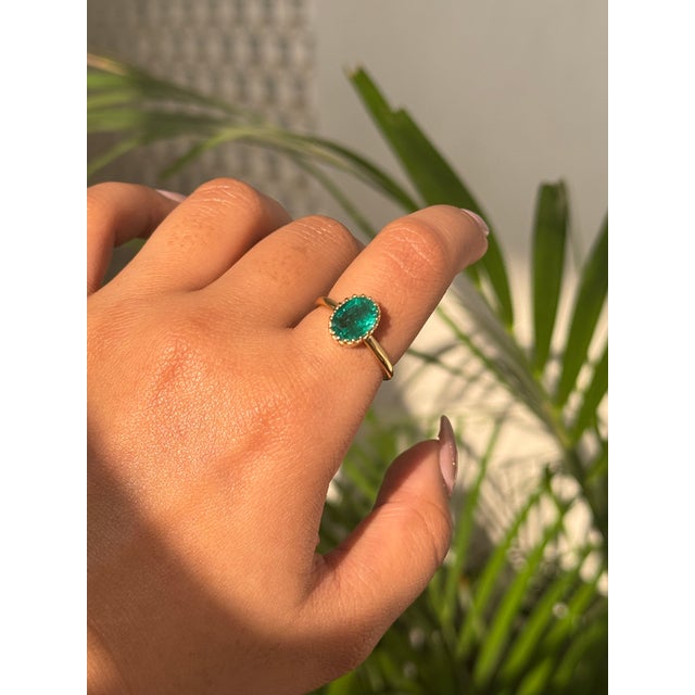 This elegant 1.9-carat oval natural emerald solitaire ring is crafted in 18K yellow gold. The emerald measures around 9.3...
