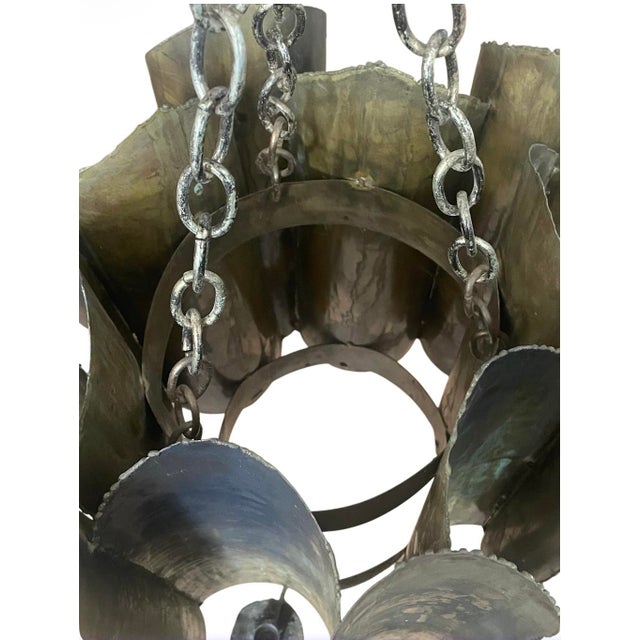 A unique and rare Brutalist torch-cut patinated brass (12) candle lantern chandelier attributed to Tom Greene for Feldman...