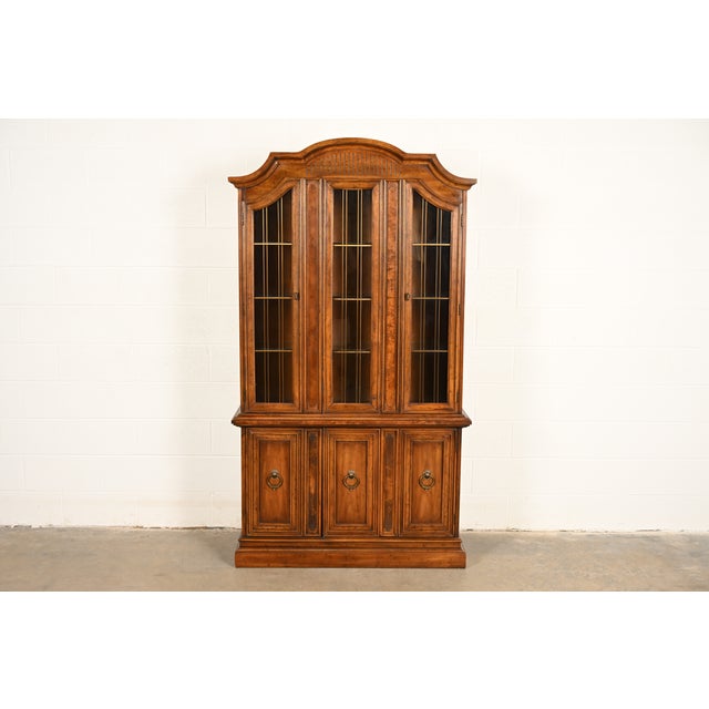 An exceptional French Regency Louis XVI style lighted breakfront bookcase cabinet By Drexel USA, Circa 1960s Walnut, with...