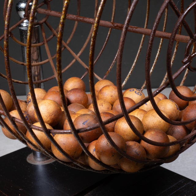 ABOUT A vintage, metal bingo cage with chrome supports, orange Bakelite handle, wooden balls and pewter ball basket...