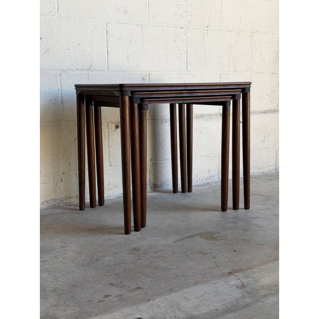 This minimalist nesting table set features three graduated accent surfaces designed to slide cleanly beneath one another....