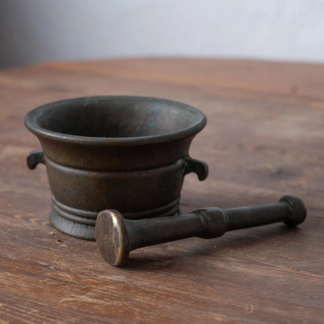 An Italian bronze mortar and pestle, 18th century. 3 ¾ inches wide by 3 ⅜ inches deep by 2 inches tall