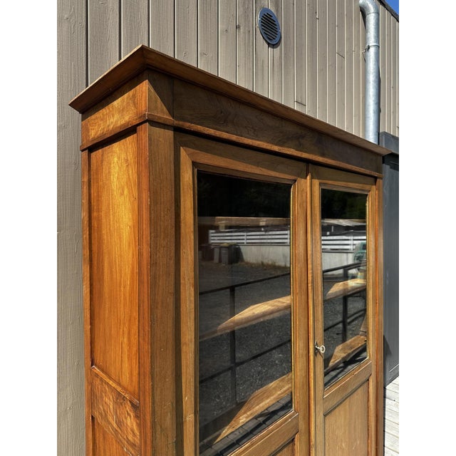 A charming solid walnut display cabinet dating from around 1900, featuring a clean and elegant design typical of French...