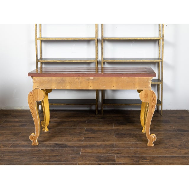 An English giltwood console table from the early 19th century with mahogany veneered top, brass banding, Vitruvian scroll...
