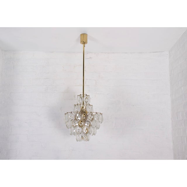 Solid brass chandelier with six levels, each decorated with pendants worked in concave circular cabochons, the light...