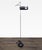 This is a stylish floor lamp by Joe Colombo for Oluce. It features a slim chrome pole, a sturdy black base, and a unique...