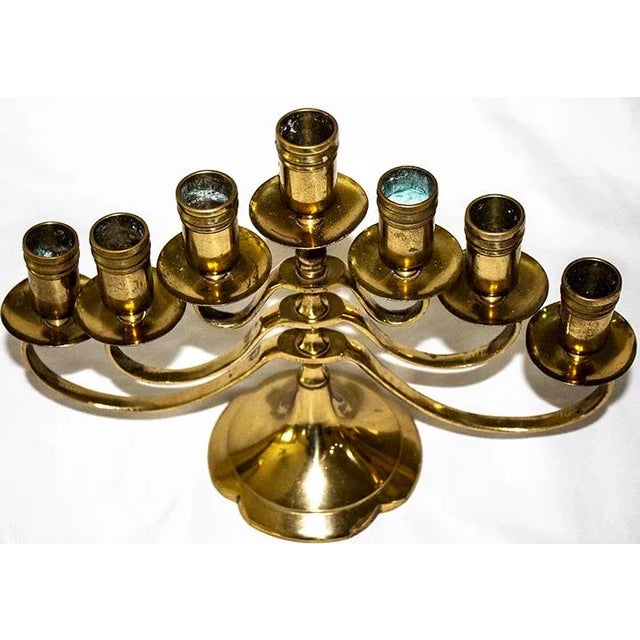 This antique solid brass swing arm Menorah candelabra holds 7 candles. It belongs to a friend who is 70 years old. This...