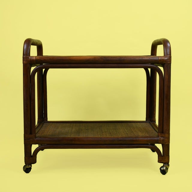 A rattan and cane bar cart, the woven cane shelves and rattan frame bringing island texture to cocktail hour. At twenty-...