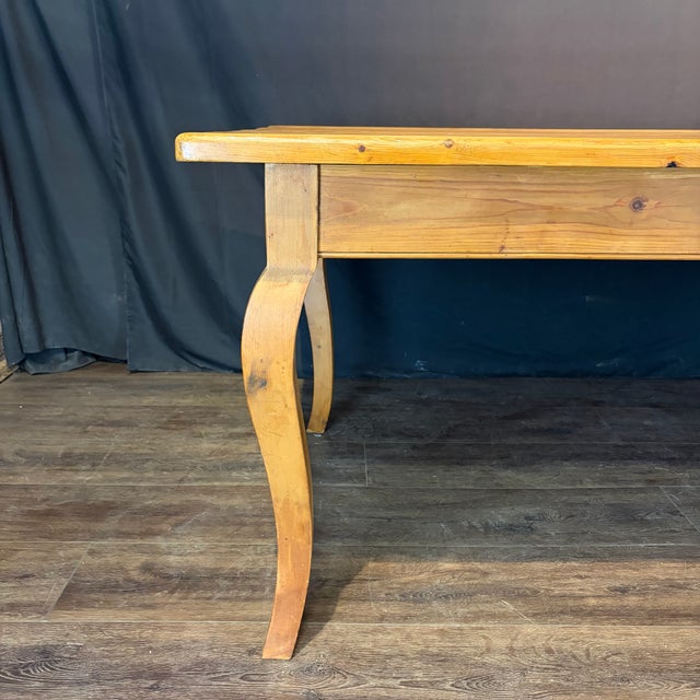 A beautifully crafted French Provincial pine farm dining table with a warm, richly developed patina and elegant, well-...