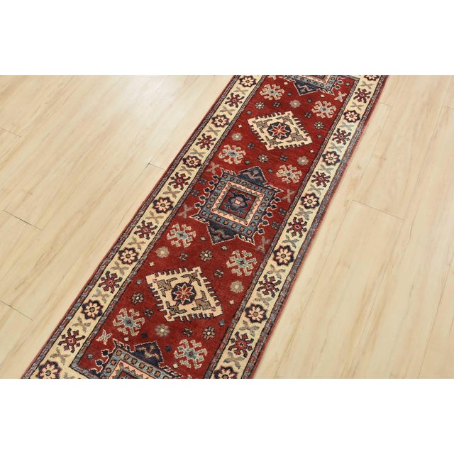 This traditional tribal geometric Caucasian Kazak runner is hand-knotted with an all-wool pile on a cotton foundation....