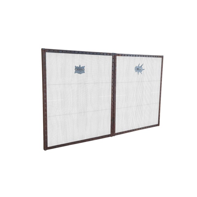 A large handmade folding fire screen. Made from iron with pierceed frame and mesh center. Features handles towards the...