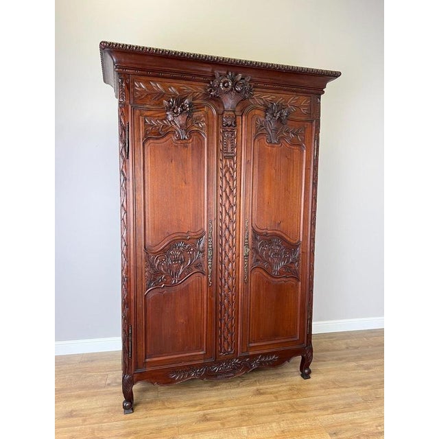An impressive Antique French wardrobe with an elegant tall form, richly carved floral decoration and an ornate two-door...
